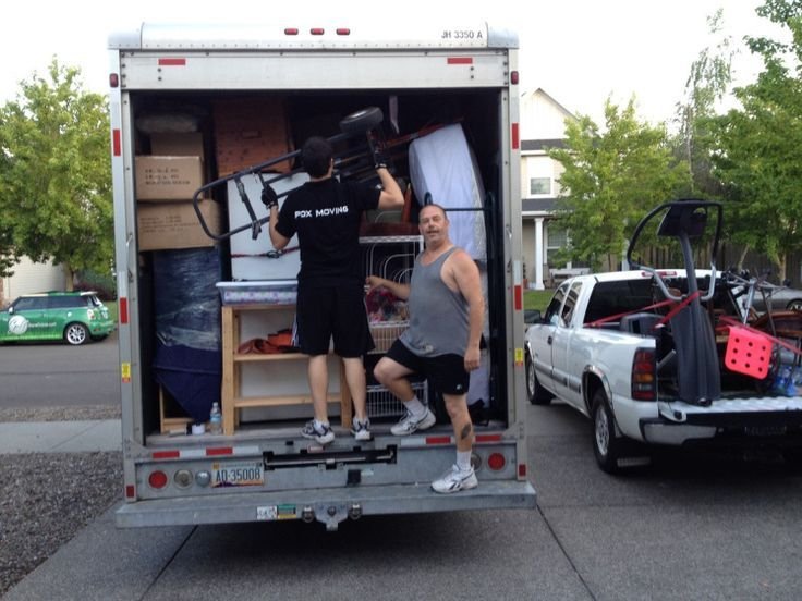 Furniture disposal service team carrying old couch out of apartment
